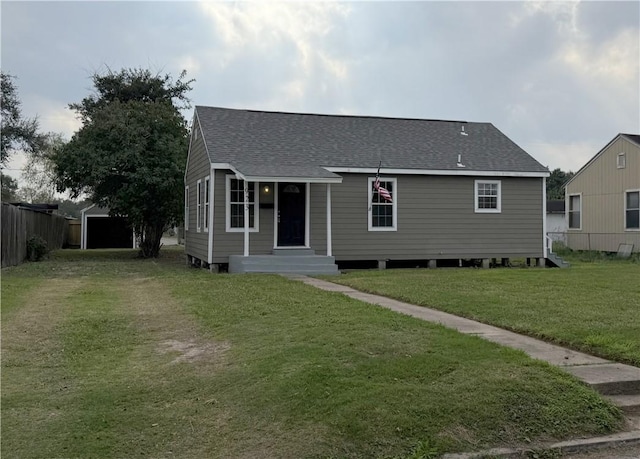 view of front of home with an outbuilding, a front lawn, and a garage