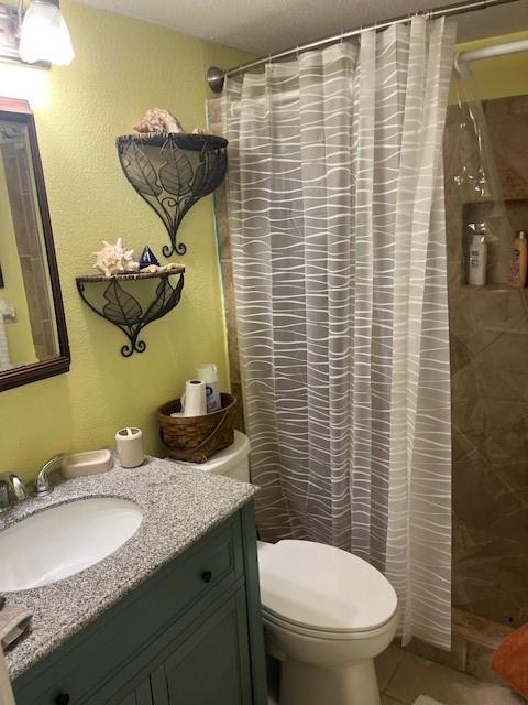 3938 Surfside Blvd Unit 1206, Corpus Christi, TX 78402 - bathroom with toilet, vanity, curtained shower, and tile patterned flooring