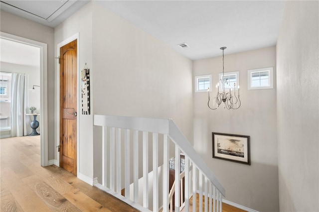 staircase featuring hardwood / wood-style floors and a chandelier