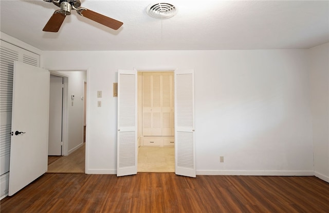 unfurnished bedroom featuring ceiling fan and dark hardwood / wood-style flooring