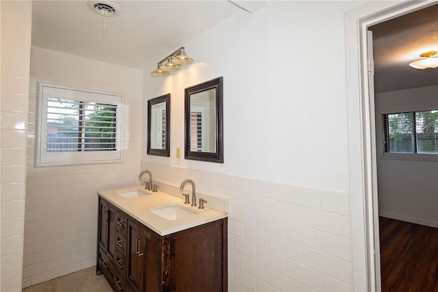 bathroom with vanity, tile walls, and hardwood / wood-style floors