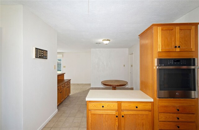 kitchen featuring stainless steel oven and a textured ceiling