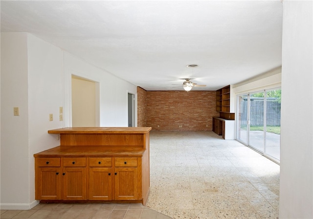 spare room with brick wall and ceiling fan