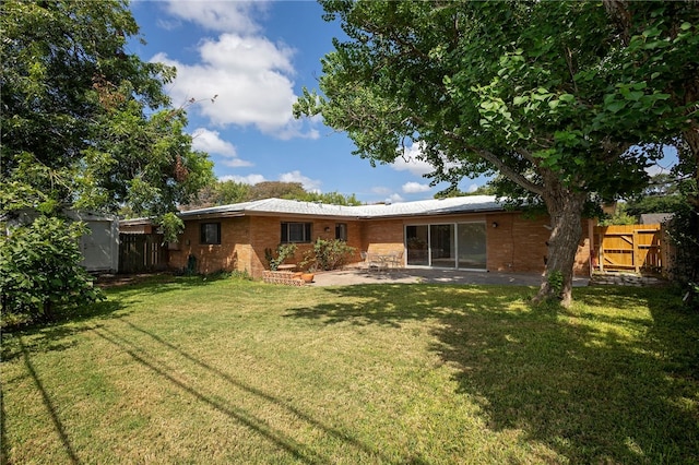 back of house featuring a patio and a lawn