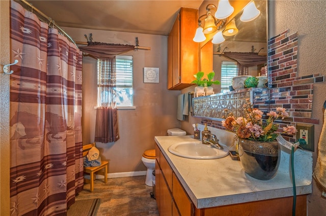 bathroom featuring a wealth of natural light, vanity, and toilet