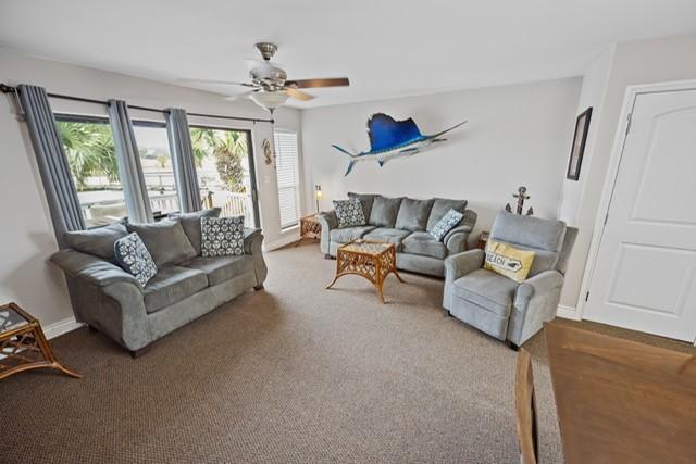 carpeted living room with ceiling fan