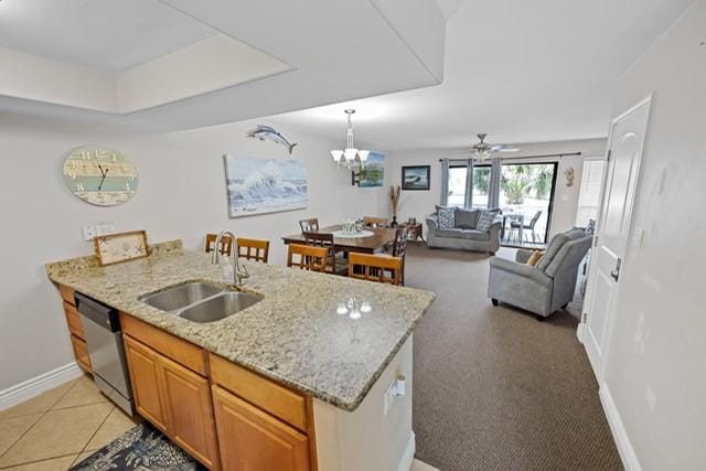 kitchen with sink, light stone counters, stainless steel dishwasher, light carpet, and ceiling fan with notable chandelier