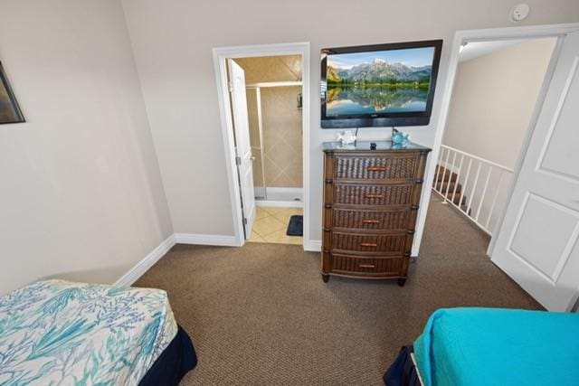 bedroom featuring ensuite bathroom and dark colored carpet