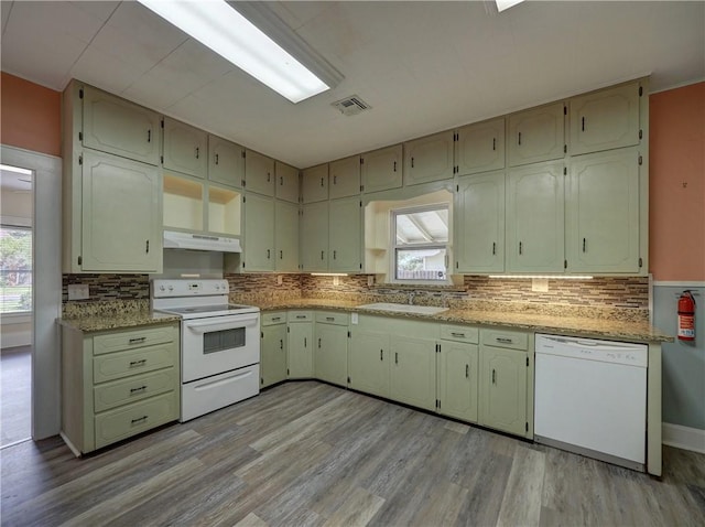 442 W Yoakum Ave, Aransas Pass, TX 78336 - kitchen with white appliances, under cabinet range hood, light wood-type flooring, a sink, and tasteful backsplash