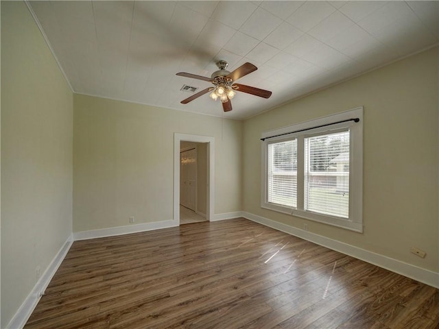 spare room with ceiling fan, dark hardwood / wood-style flooring, and ornamental molding