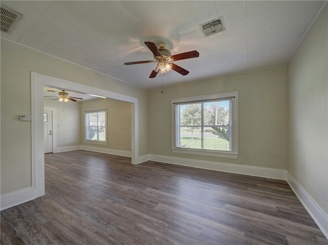 unfurnished room featuring ceiling fan, plenty of natural light, and dark wood-type flooring