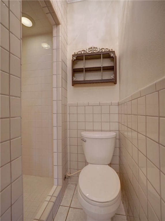 bathroom featuring tile patterned flooring, toilet, and tile walls