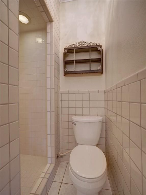 442 W Yoakum Ave, Aransas Pass, TX 78336 - full bath with toilet, tile walls, a tile shower, a wainscoted wall, and tile patterned flooring