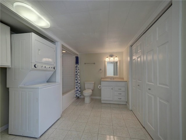 442 W Yoakum Ave, Aransas Pass, TX 78336 - full bathroom with stacked washing machine and dryer, toilet, vanity, tile patterned flooring, and shower / bathtub combination with curtain