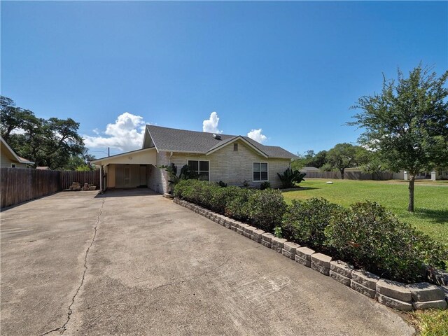 442 W Yoakum Ave, Aransas Pass, TX 78336 - view of side of property featuring concrete driveway and an attached carport