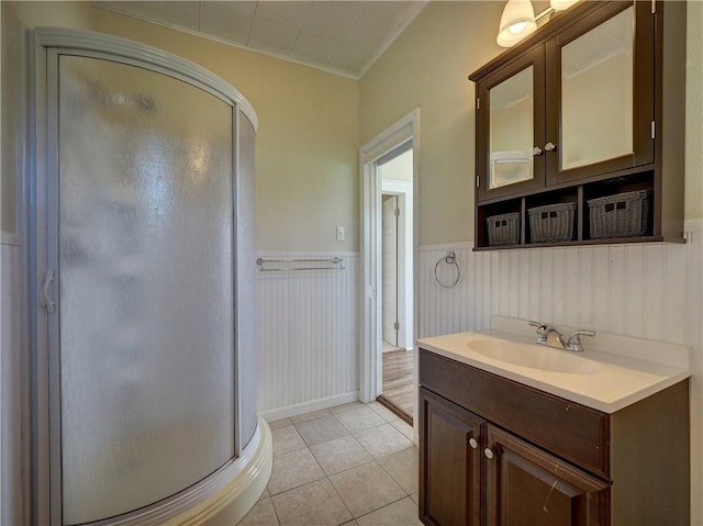 442 W Yoakum Ave, Aransas Pass, TX 78336 - bathroom featuring a shower stall, a wainscoted wall, vanity, tile patterned floors, and crown molding