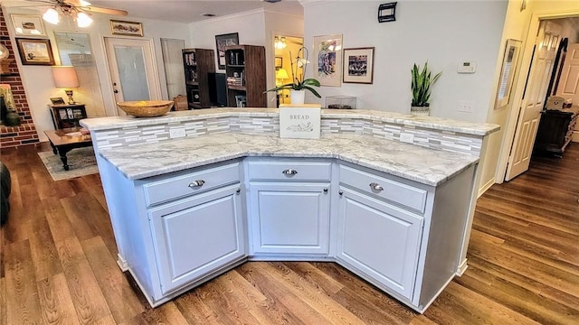 1017 Hickory Ave, Rockport, TX 78382 - kitchen featuring wood finished floors, a center island, a ceiling fan, light stone countertops, and ornamental molding