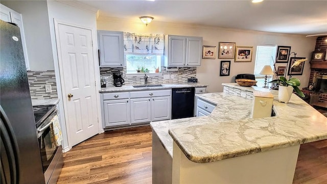 1017 Hickory Ave, Rockport, TX 78382 - kitchen with black appliances, a sink, crown molding, wood finished floors, and plenty of natural light