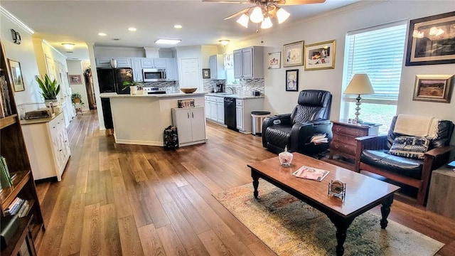 1017 Hickory Ave, Rockport, TX 78382 - living area with crown molding, ceiling fan, wood finished floors, and recessed lighting