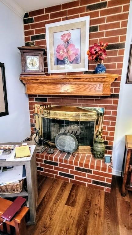 1017 Hickory Ave, Rockport, TX 78382 - detailed view of a brick fireplace, ornamental molding, and wood finished floors