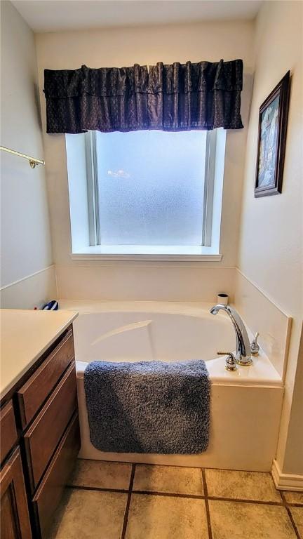 1017 Hickory Ave, Rockport, TX 78382 - full bathroom with a garden tub, vanity, and tile patterned flooring