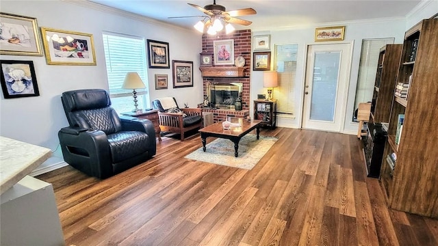 1017 Hickory Ave, Rockport, TX 78382 - living area with a ceiling fan, wood finished floors, ornamental molding, a fireplace, and baseboards