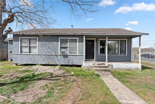 bungalow-style house with cooling unit, fence, and a front yard