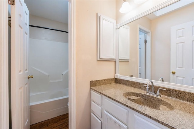 full bath with shower / bathtub combination, toilet, wood finished floors, and vanity