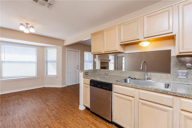 kitchen with visible vents, a sink, stainless steel dishwasher, light wood-style floors, and light countertops