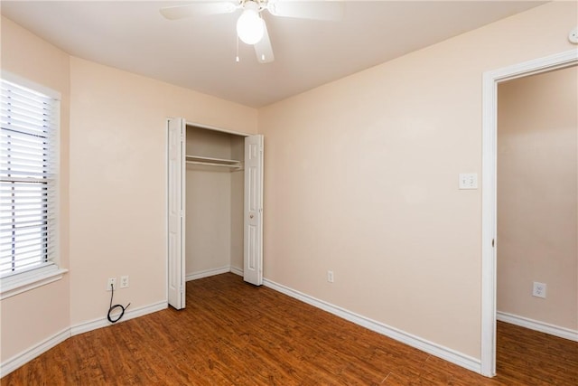 unfurnished bedroom with wood finished floors, baseboards, and a closet