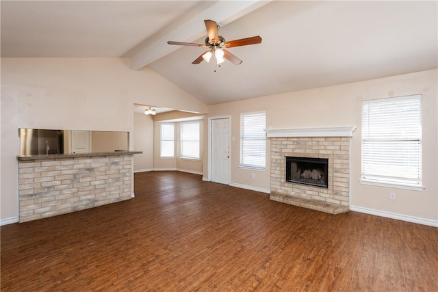 unfurnished living room featuring wood finished floors, a ceiling fan, baseboards, lofted ceiling with beams, and a fireplace