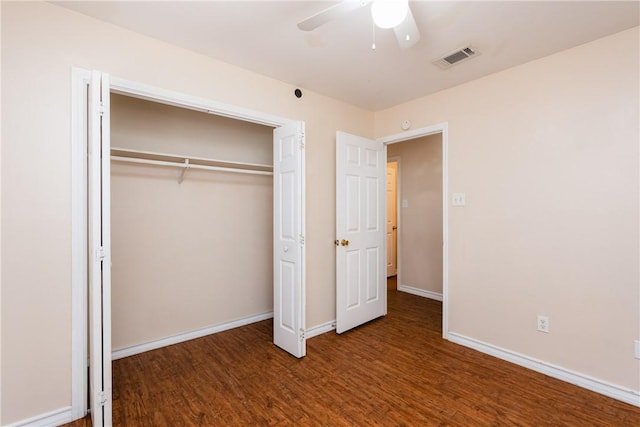 unfurnished bedroom featuring wood finished floors, visible vents, baseboards, ceiling fan, and a closet