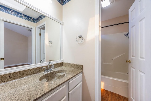 bathroom featuring bathtub / shower combination, wood finished floors, and vanity