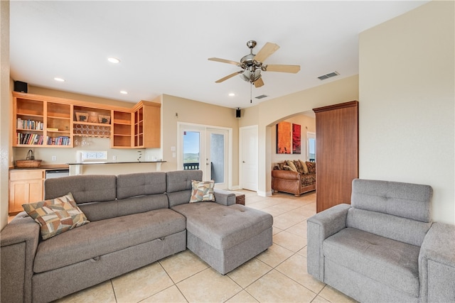 living room featuring french doors, light tile patterned flooring, and ceiling fan