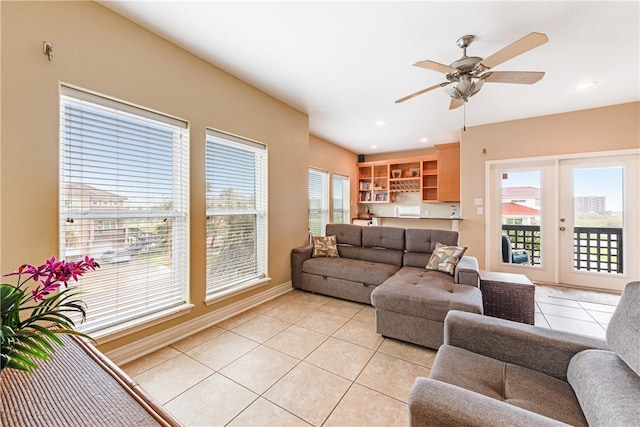 tiled living room with ceiling fan and french doors