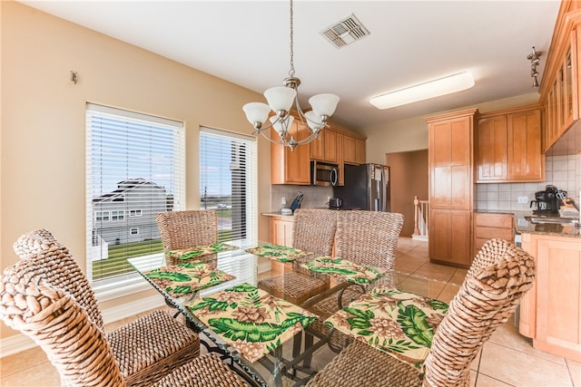 dining space featuring a notable chandelier and light tile patterned floors