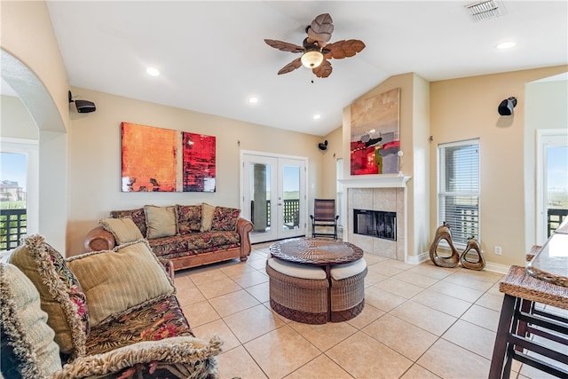 living room with a healthy amount of sunlight, vaulted ceiling, and light tile patterned floors