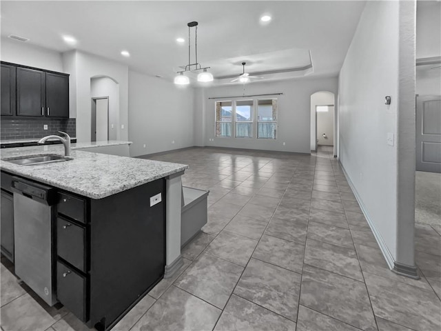 kitchen with dishwasher, a kitchen island with sink, sink, ceiling fan, and decorative light fixtures