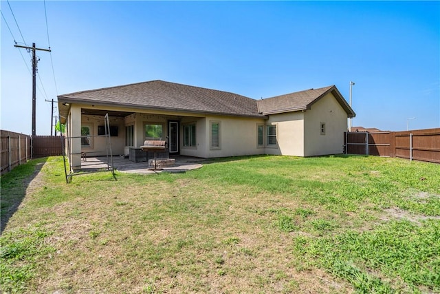 rear view of property featuring a fenced backyard, a lawn, stucco siding, and a patio area