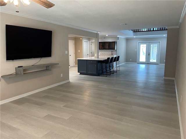 7029 Tamarron Ct, Corpus Christi, TX 78413 - living room featuring ornamental molding, baseboards, light wood-style floors, french doors, and a ceiling fan