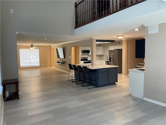 7029 Tamarron Ct, Corpus Christi, TX 78413 - kitchen with stainless steel appliances, light countertops, light wood-type flooring, a breakfast bar, and a ceiling fan