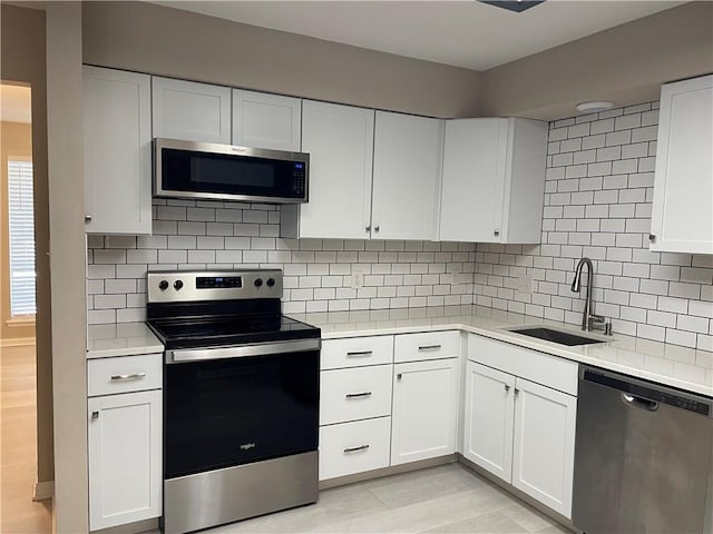 7029 Tamarron Ct, Corpus Christi, TX 78413 - kitchen featuring appliances with stainless steel finishes, a sink, light countertops, and white cabinets