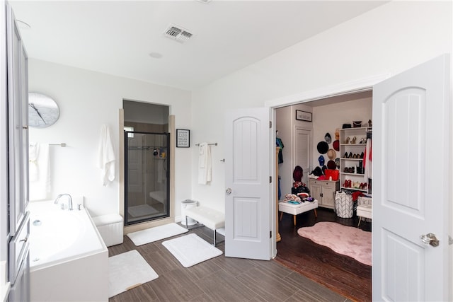 bathroom featuring hardwood / wood-style floors and separate shower and tub