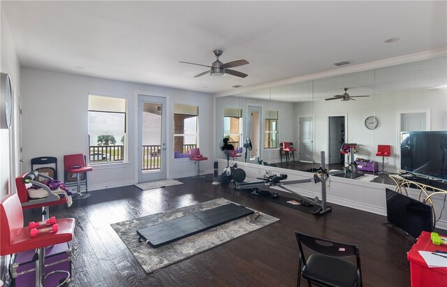 exercise area with dark hardwood / wood-style flooring, ornamental molding, and ceiling fan