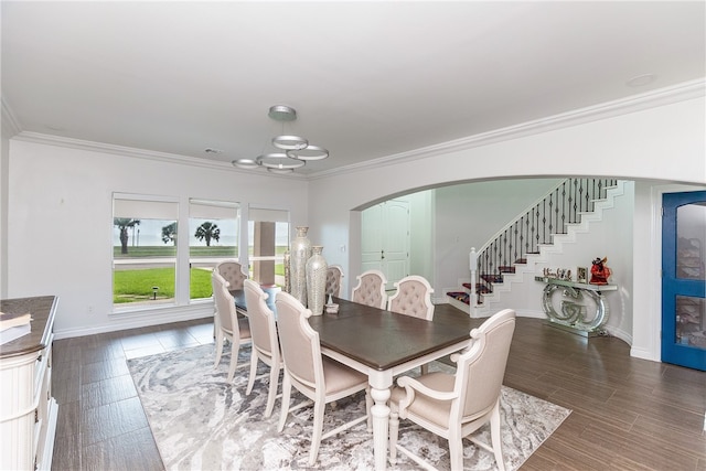 dining space with ornamental molding, an inviting chandelier, and dark hardwood / wood-style floors