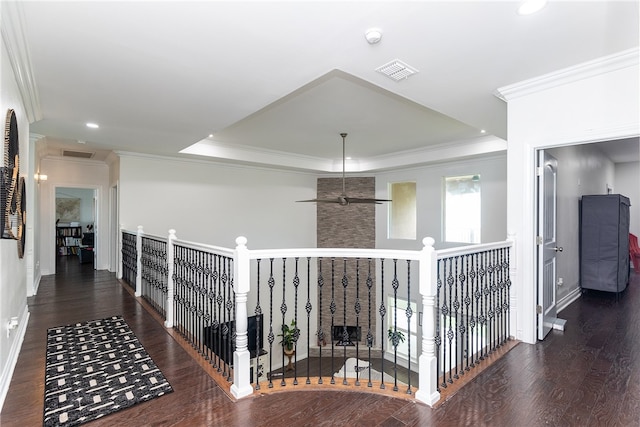 hall featuring crown molding, a raised ceiling, and dark hardwood / wood-style flooring