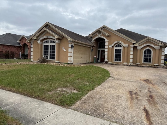 view of front facade featuring an attached garage, concrete driveway, a front yard, and stucco siding