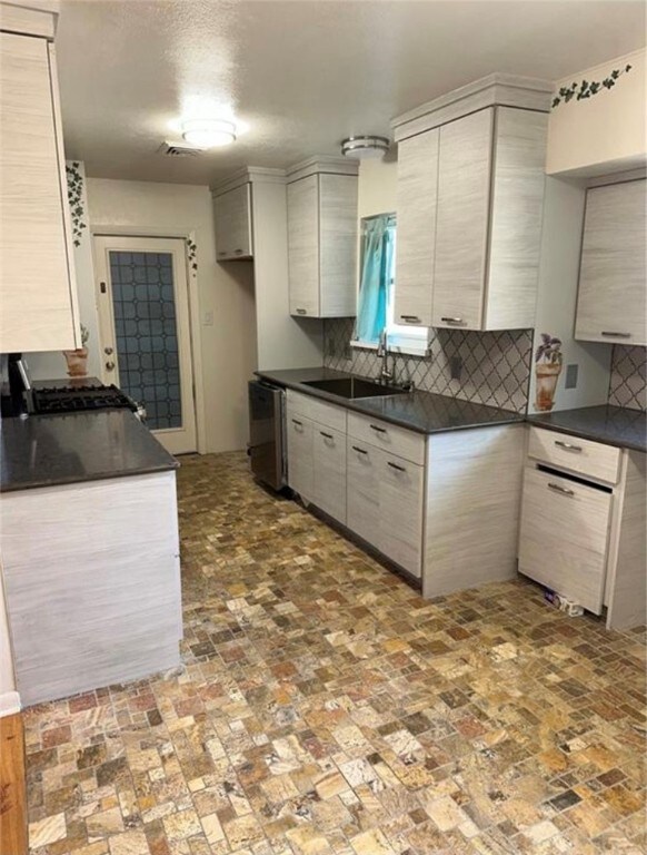 kitchen with stainless steel appliances, sink, and tasteful backsplash