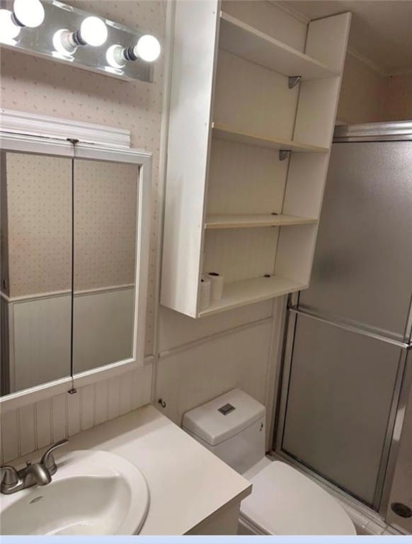 bathroom with toilet, vanity, and an enclosed shower