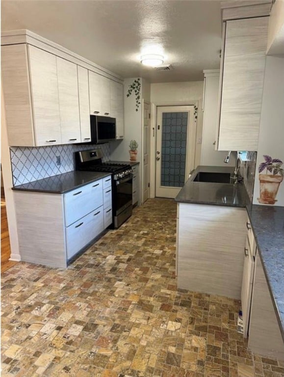 kitchen featuring tasteful backsplash, sink, light brown cabinetry, and stainless steel appliances